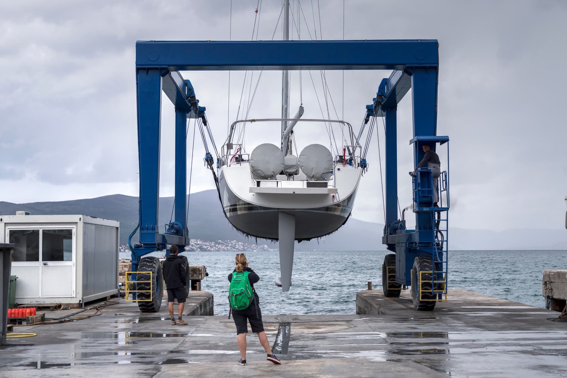 Representative view of a sailboat supported by a marina travel lift